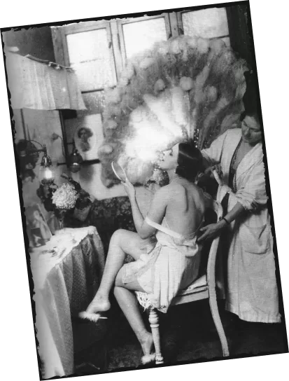 Historisches Foto: Cabaret-Künstlerin mit Federkopfschmuck wird backstage angekleidet